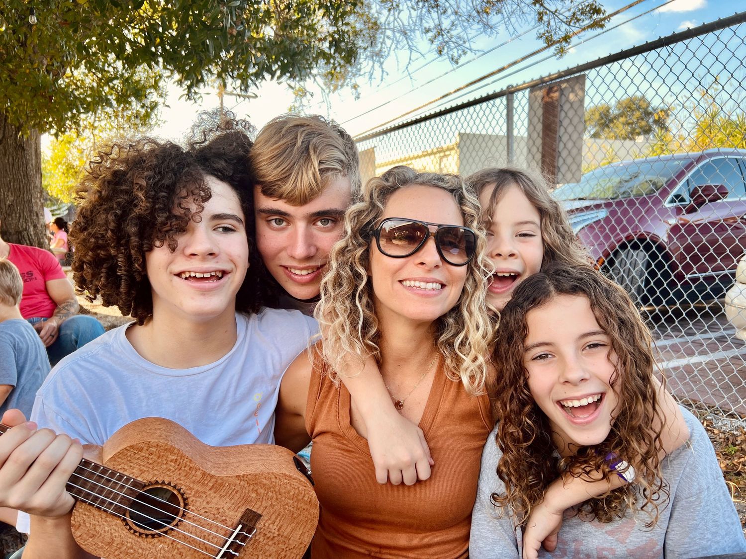 Group enjoying outdoor activities with a ukulele on a sunny day.