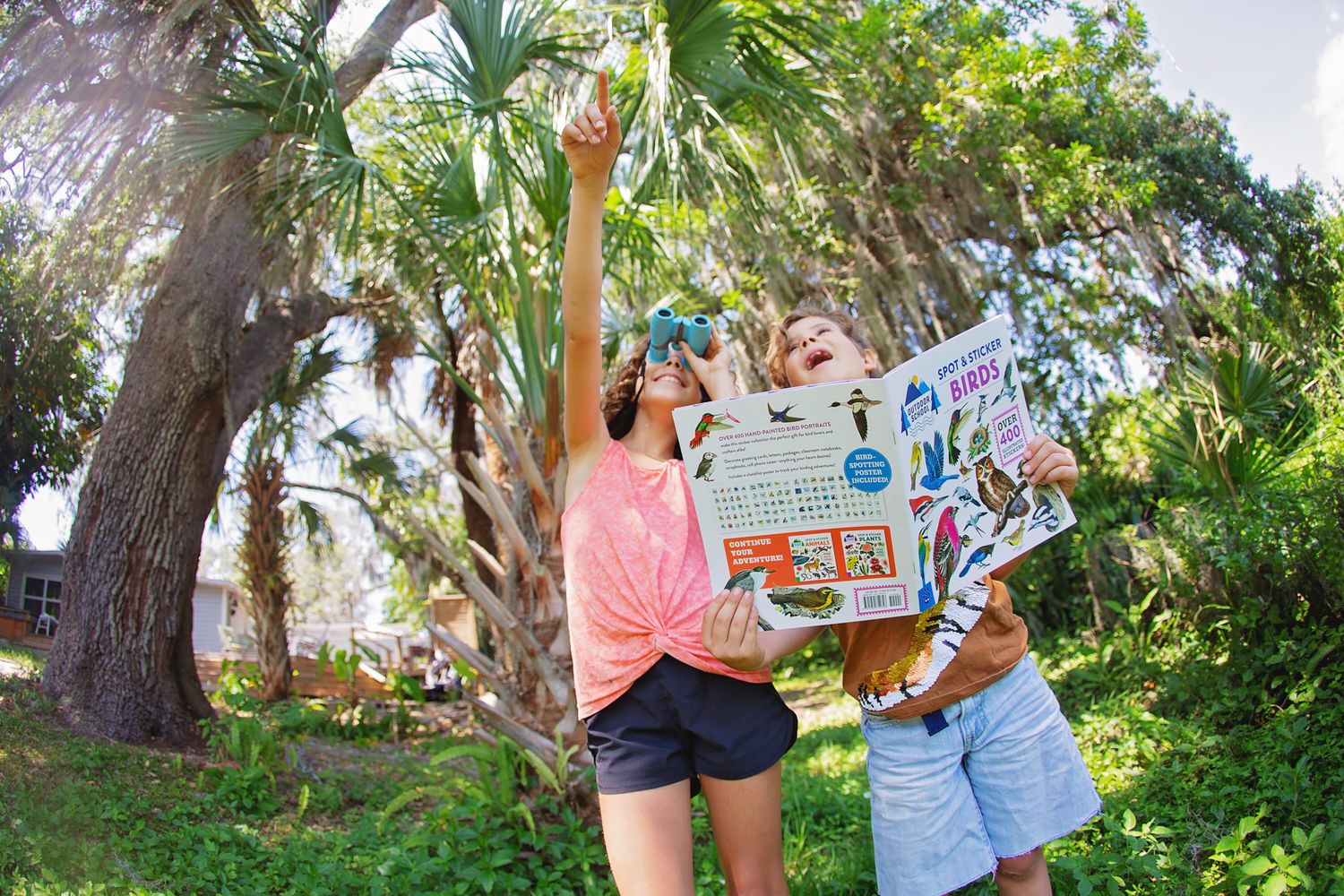 Family painting together outdoors among tropical palm trees.