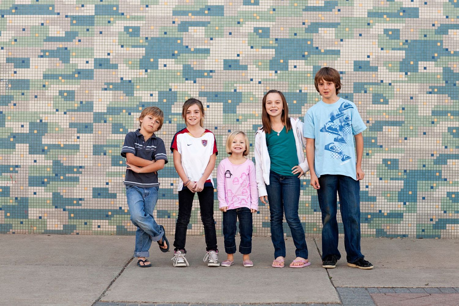 A group stands against a blue and white geometric patterned wall.