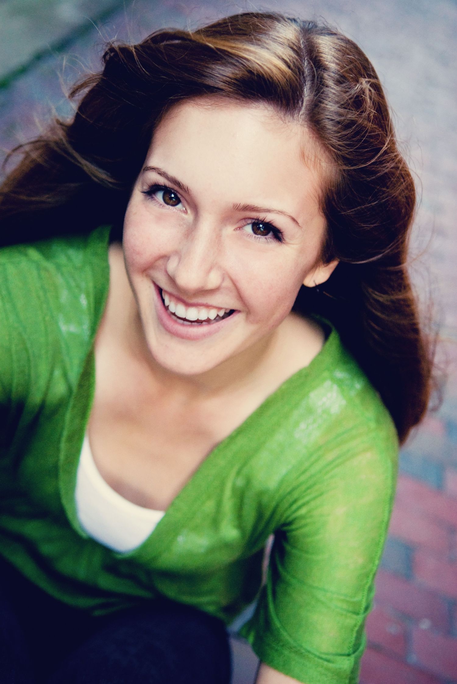 Portrait in bright green top with joyful expression.