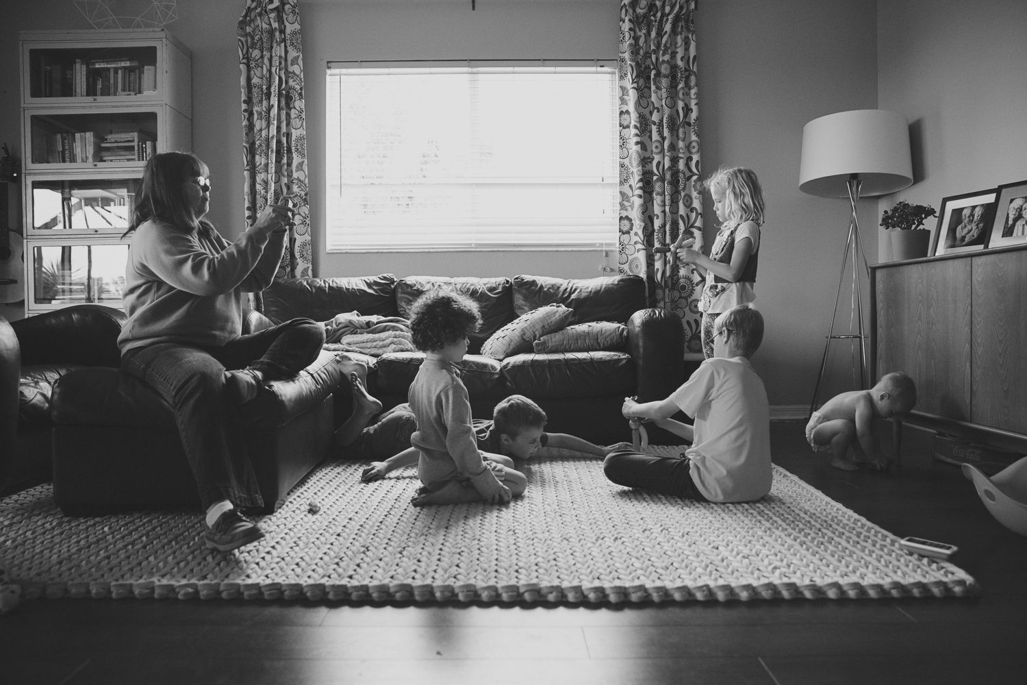 A family enjoys quality time together playing on a living room floor.