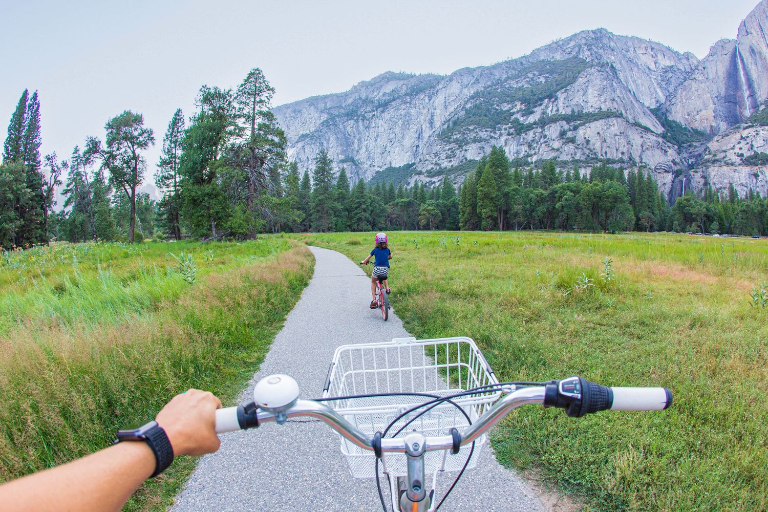 First-person view of cycling on a trail with mountain views in the background.