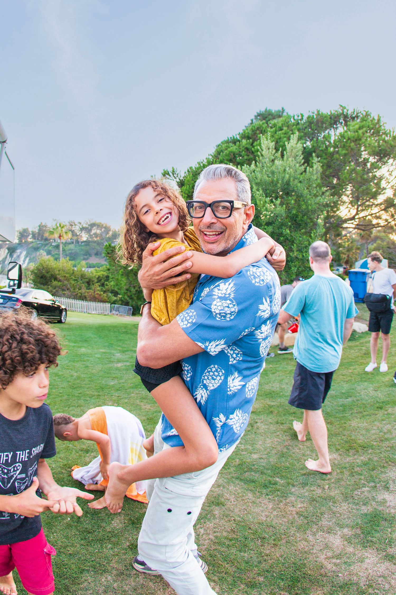 People playing and having fun at an outdoor gathering on a grassy lawn.