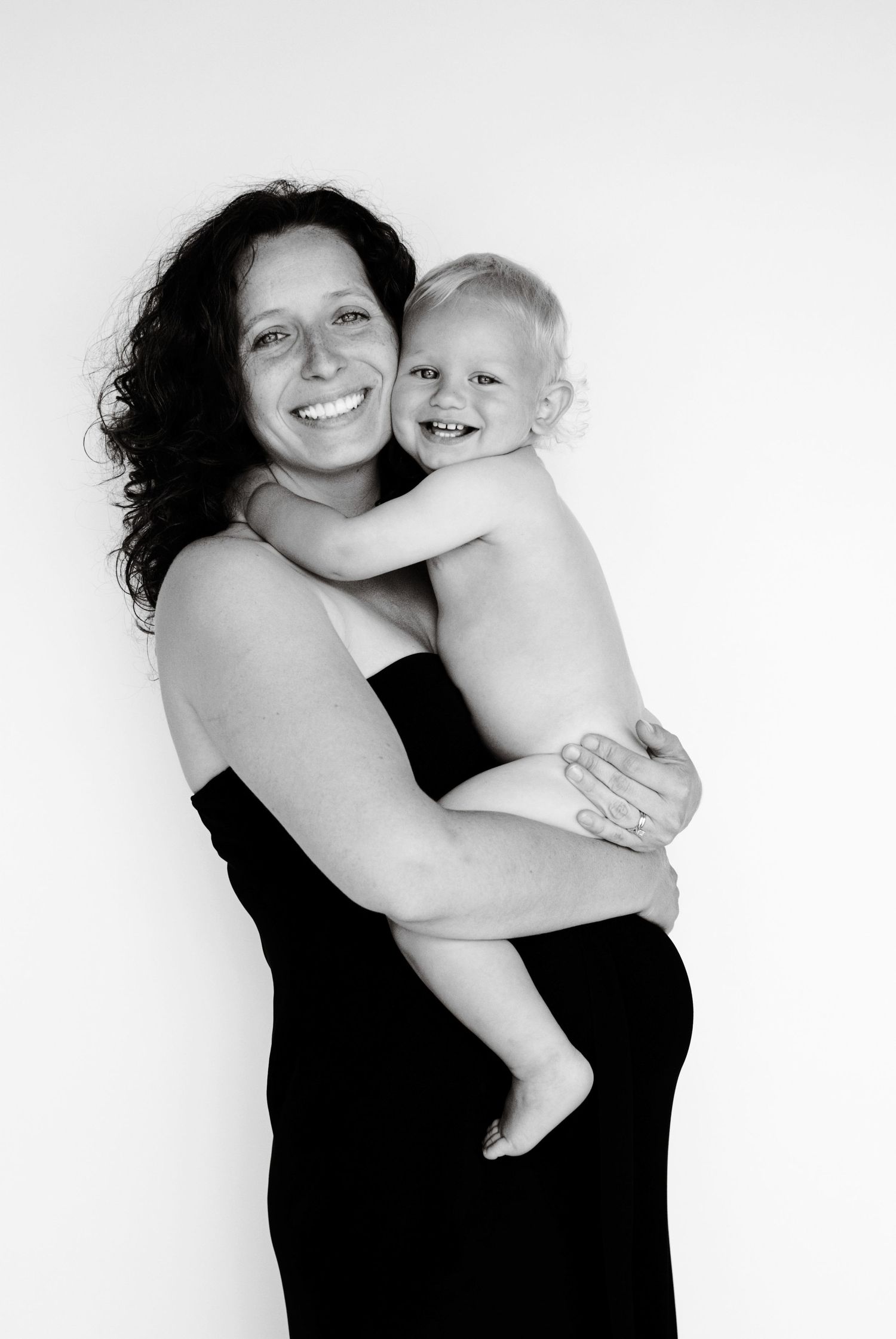 A heartwarming black and white portrait of a mother and child sharing a joyful embrace.