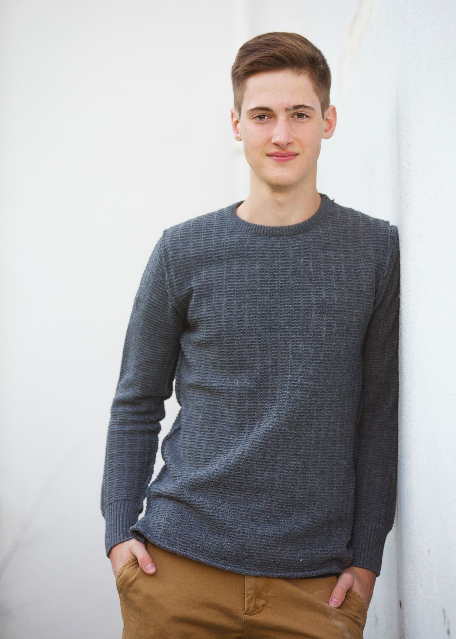 Portrait of person in grey sweater against white background.