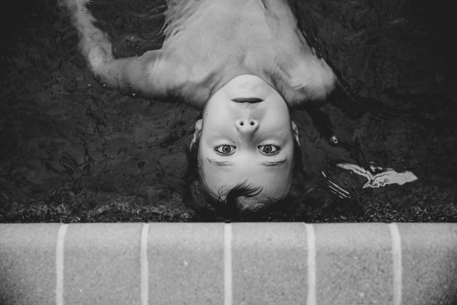 An artistic black and white portrait shot from above showing an upside-down perspective.