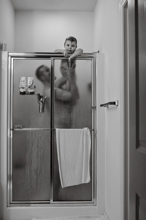 Playful moment captured through foggy glass shower door.