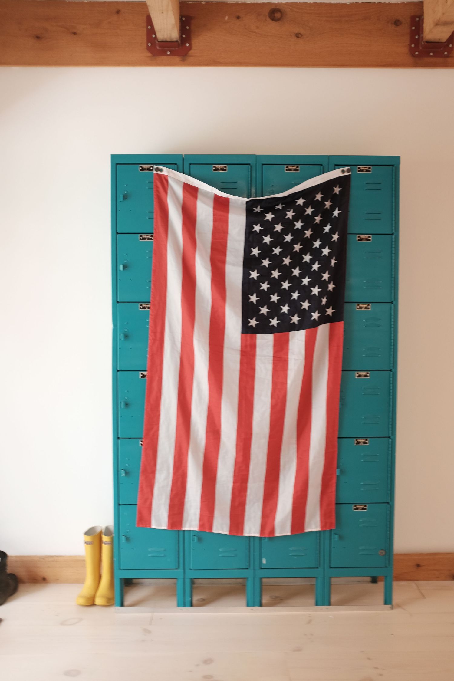 American flag displayed on turquoise lockers with yellow rain boots beside them.