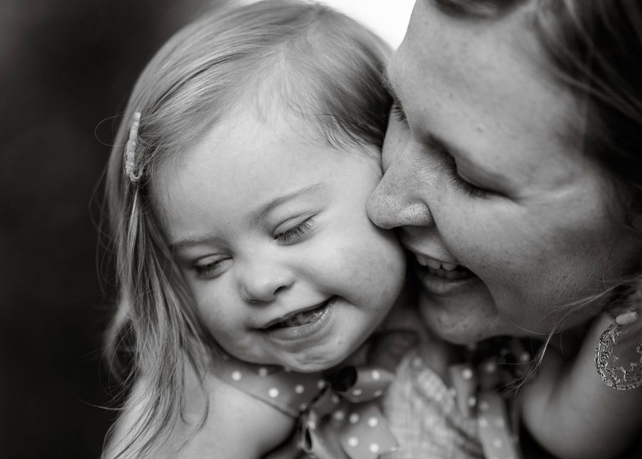 A tender black and white portrait captures an intimate moment between parent and child.