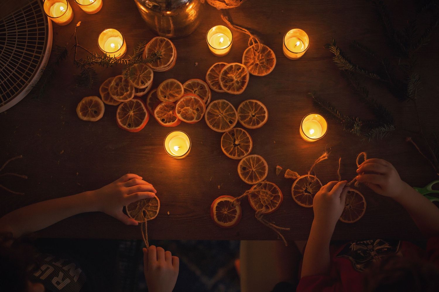 Hands hold glowing bubbles against dark background with warm candlelight.