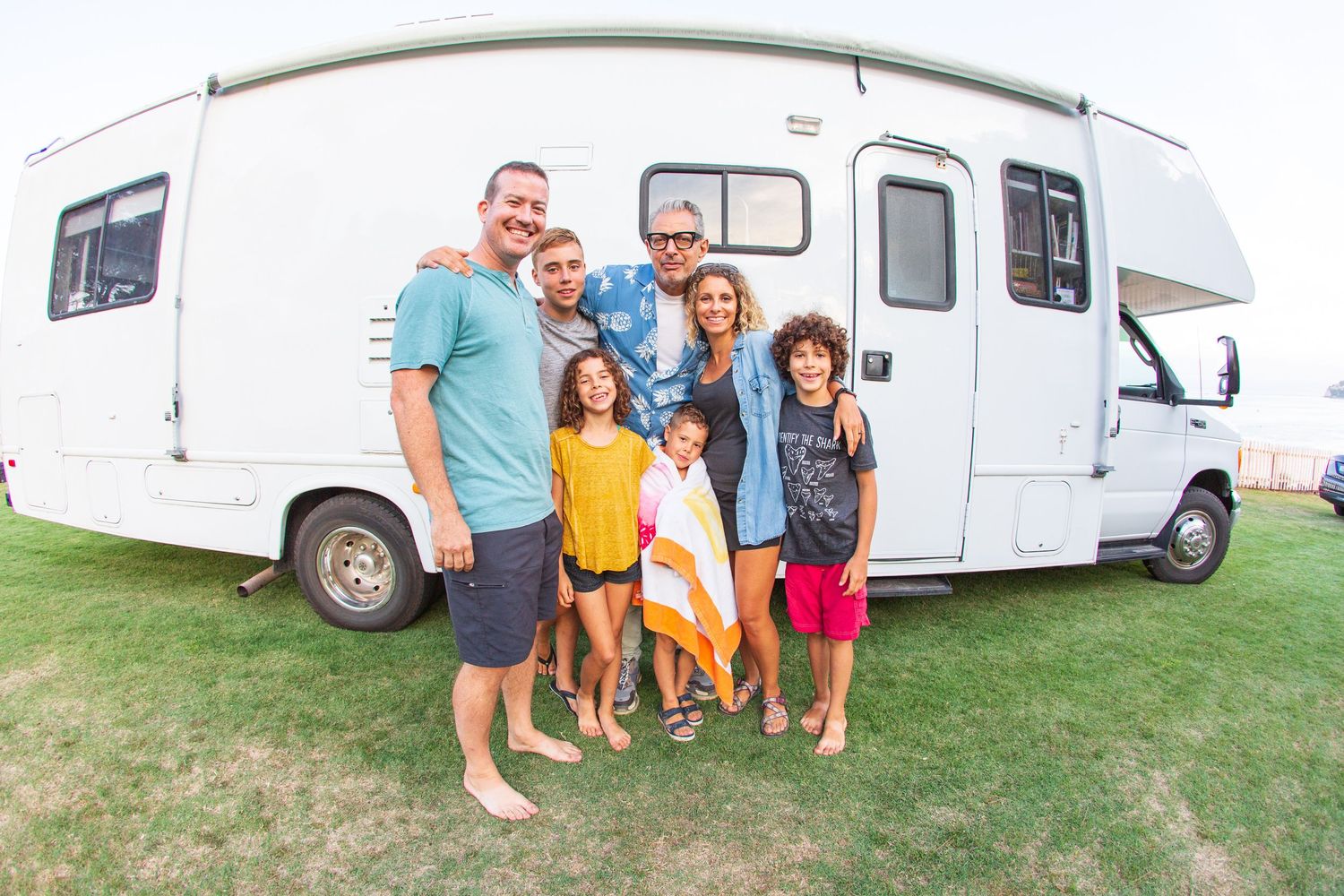 A recreational vehicle parked on grass during a family camping trip.