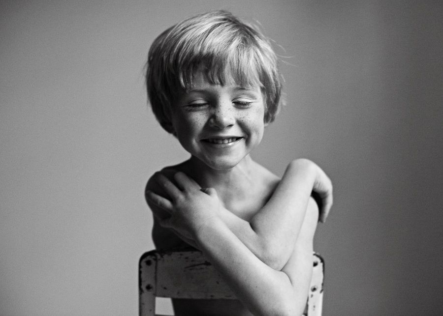 A candid black and white portrait showing pure joy and laughter.