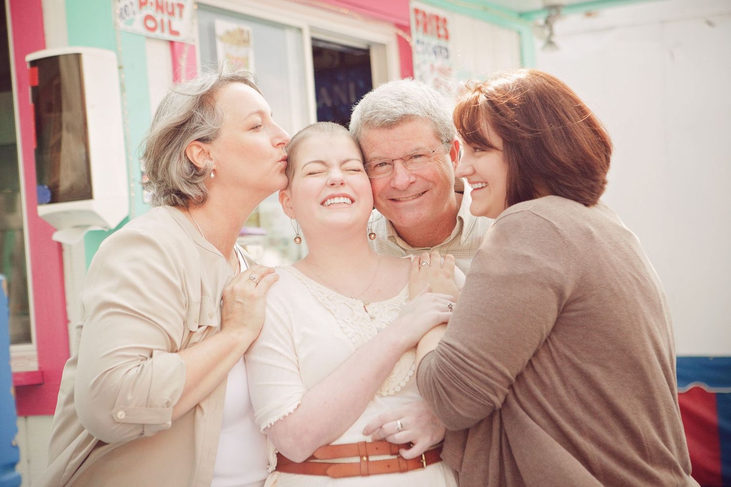 A group shares an intimate moment of laughter and hugs indoors.