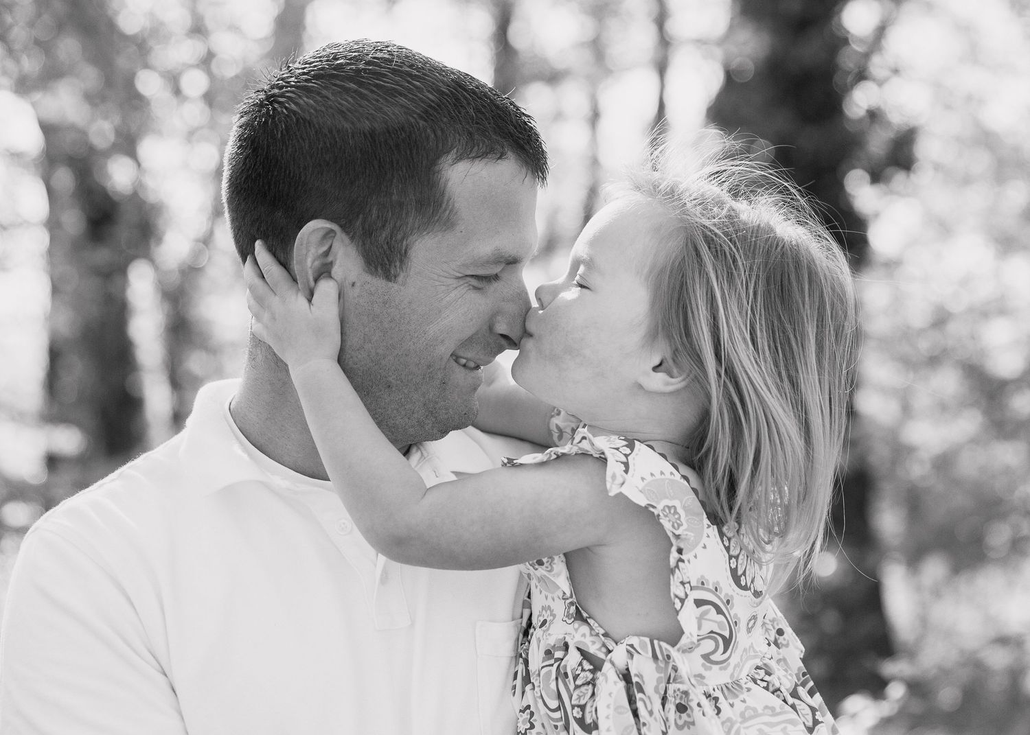 Black and white intimate moment between parent and child outdoors.