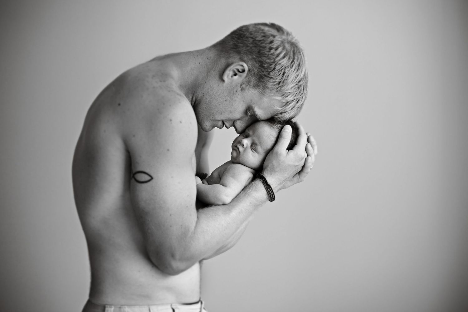 Black and white artistic portrait of tender moment between parent and infant.