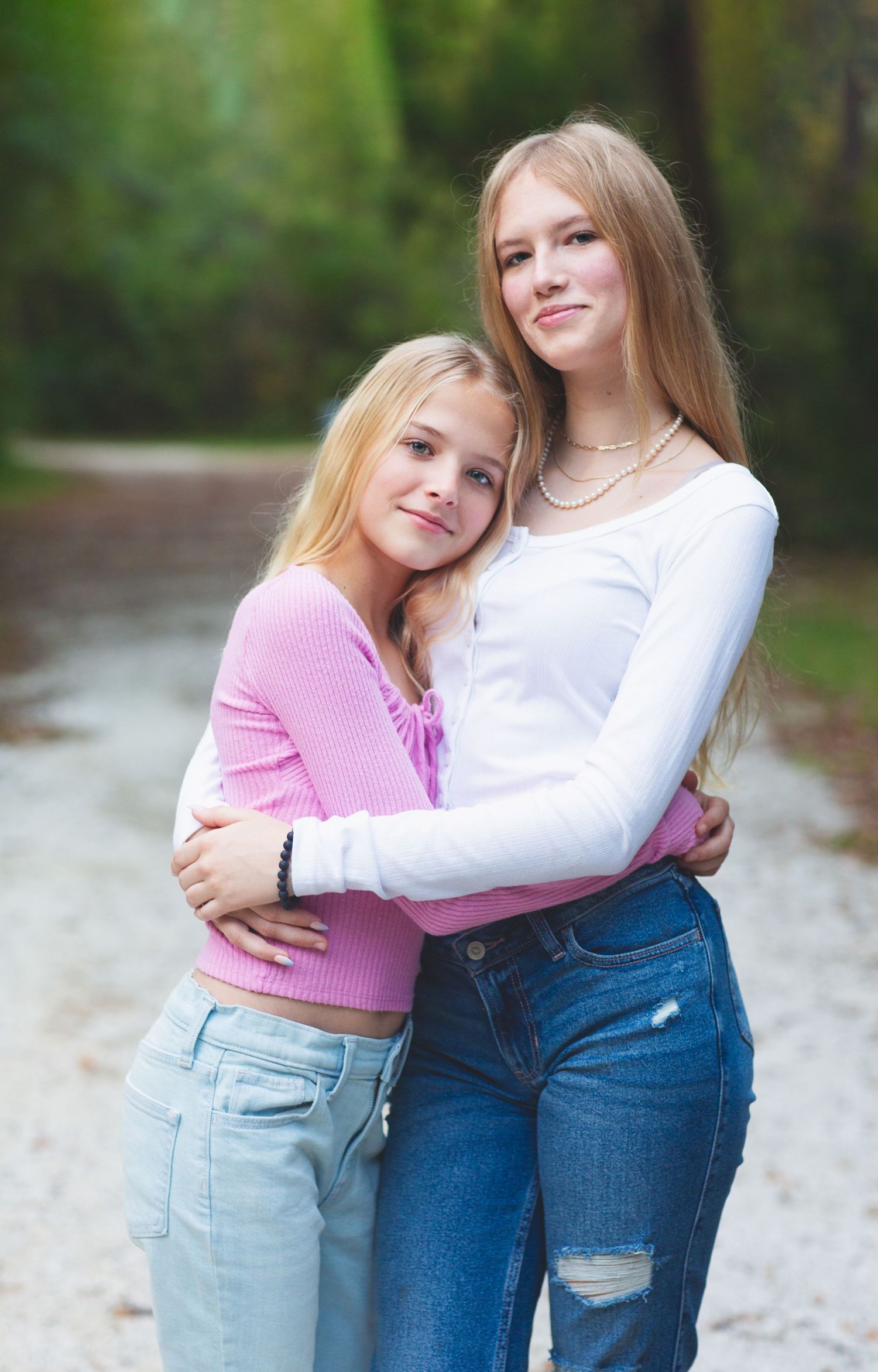 Two people embracing outdoors wearing casual denim and sweaters.