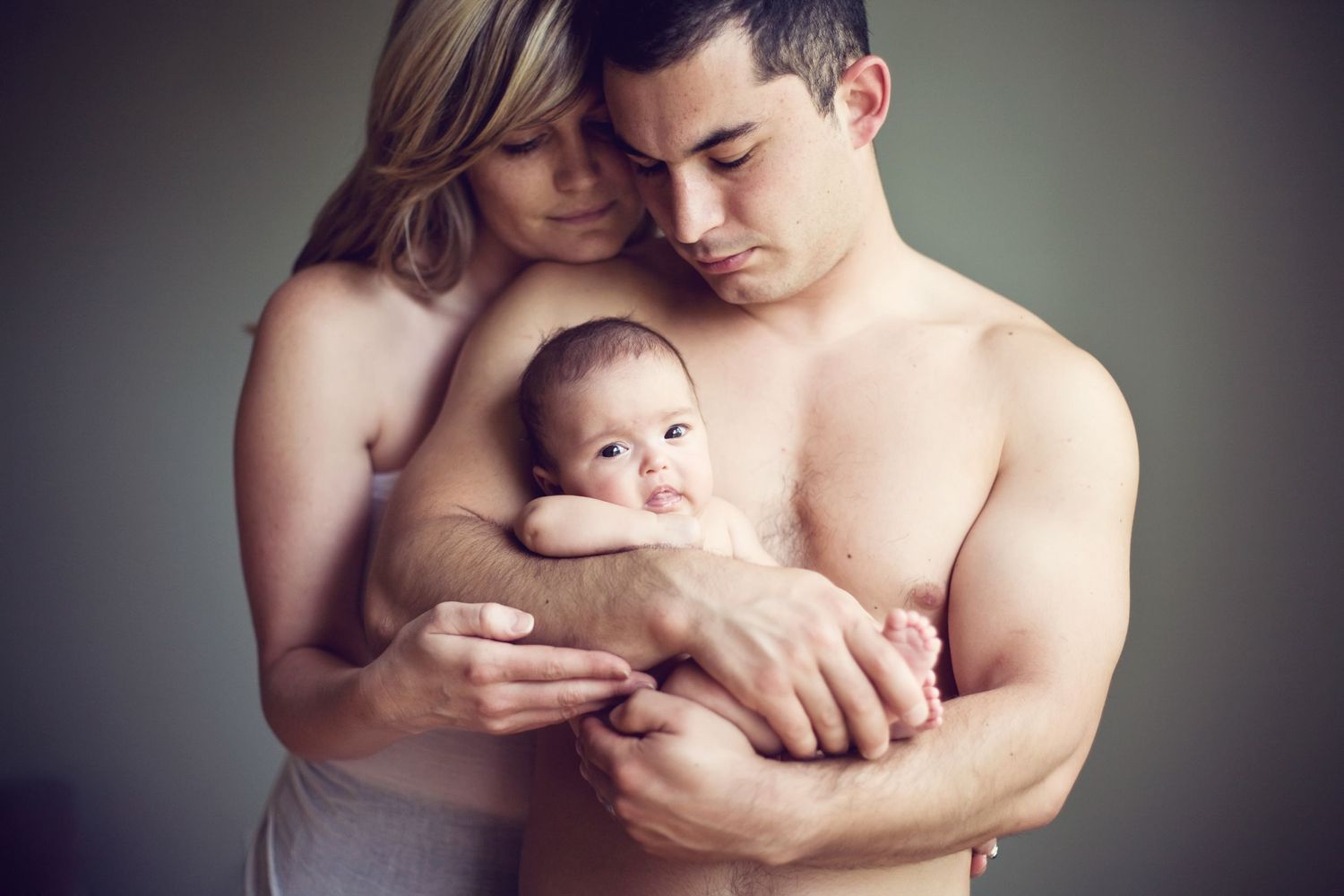 An intimate family portrait showing tender moments with a newborn baby.
