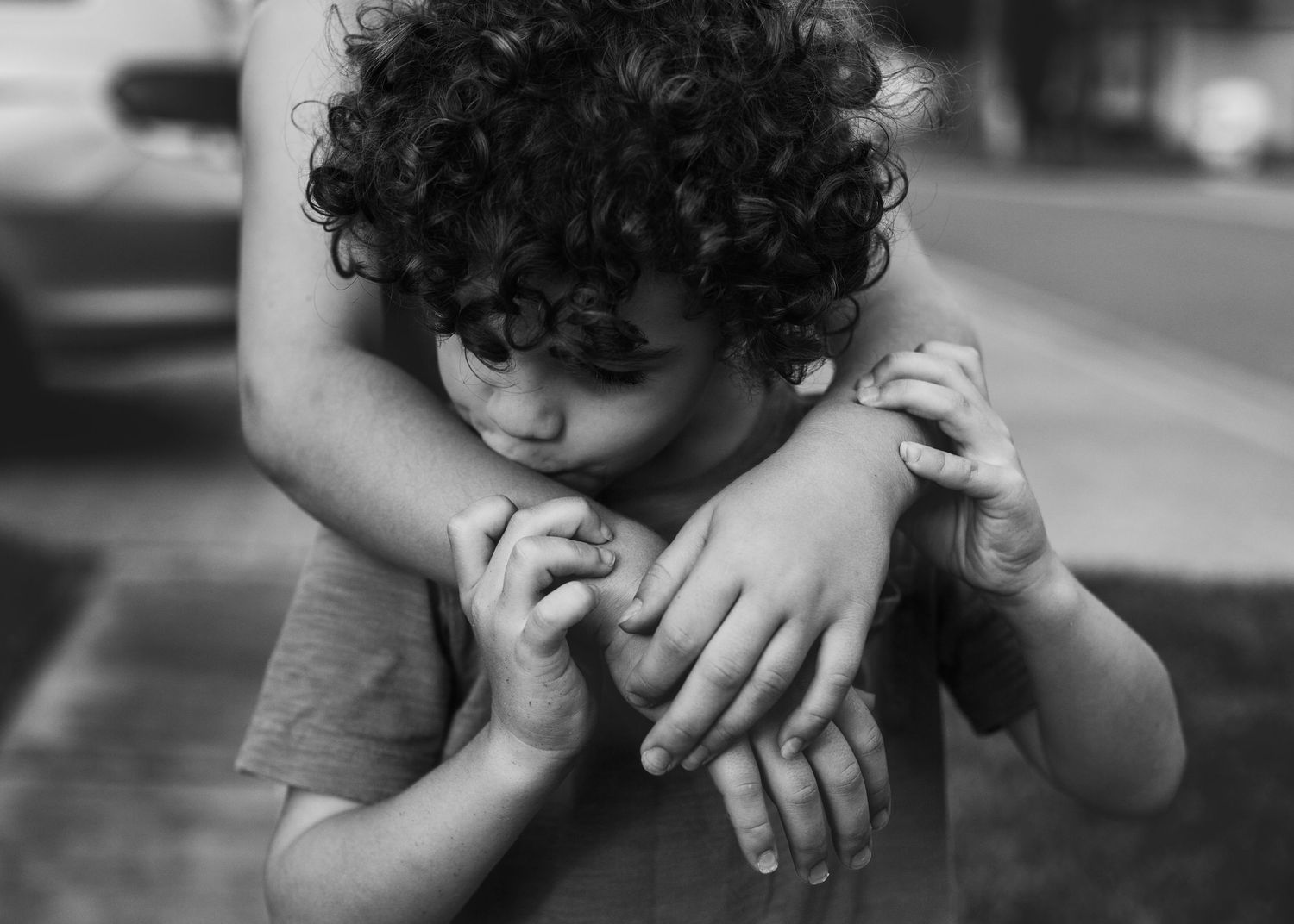Black and white image showing hands gently embracing with tenderness and care.