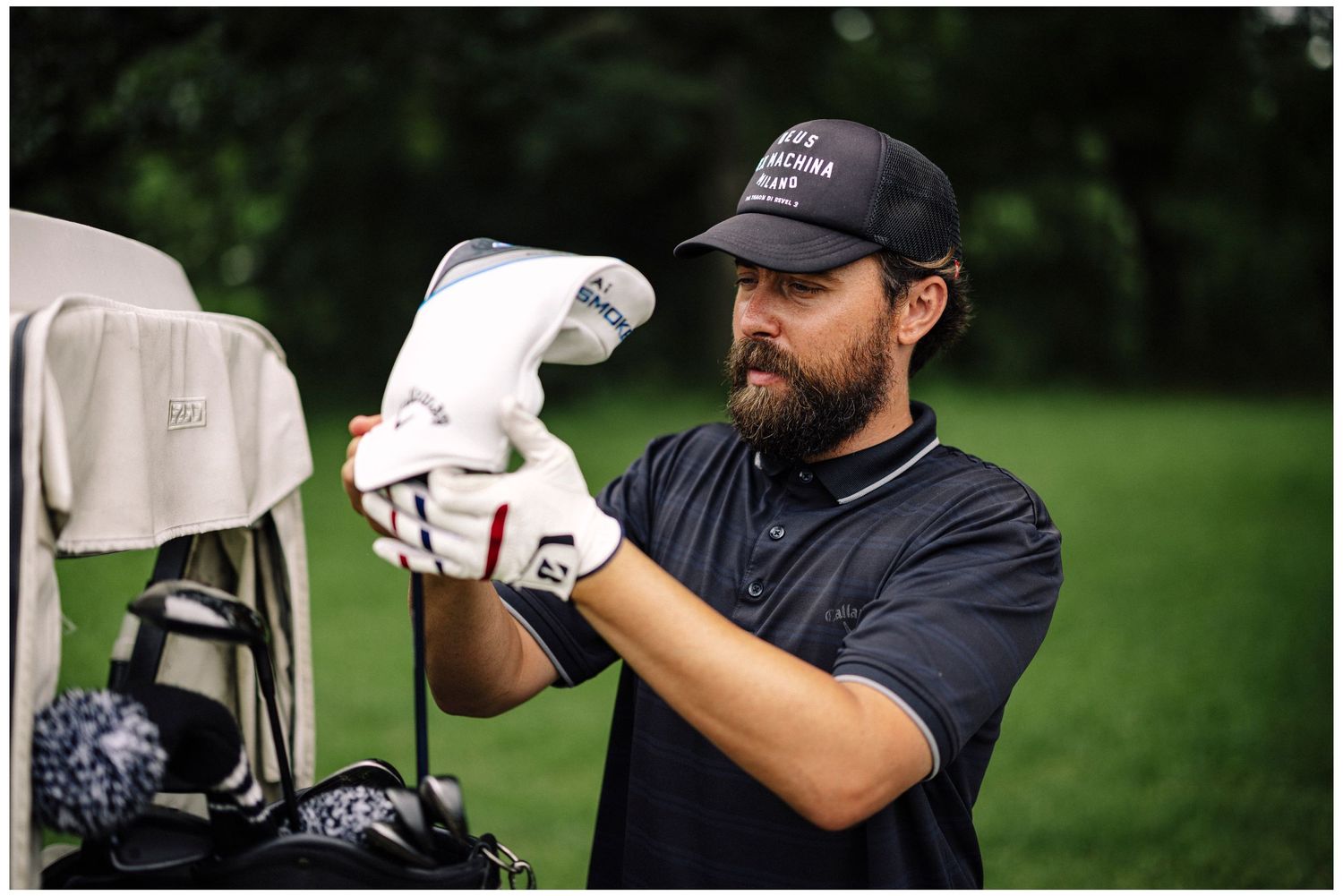 Golfer crouching to analyze the green while holding putter.