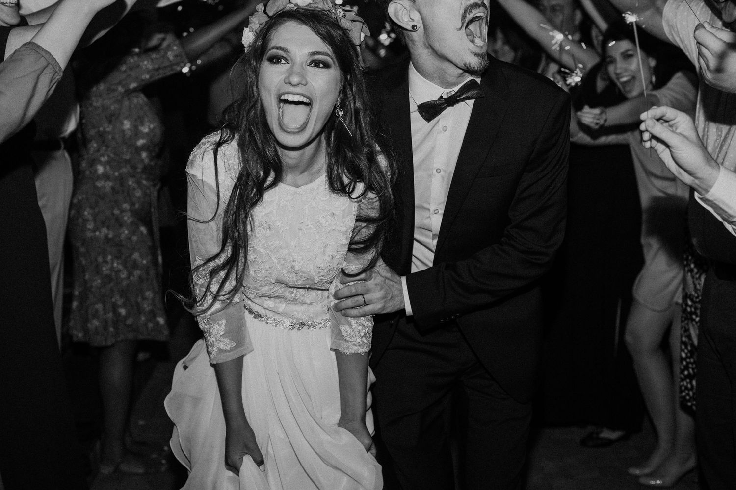 Black and white photo of joyful dancing at a wedding reception.