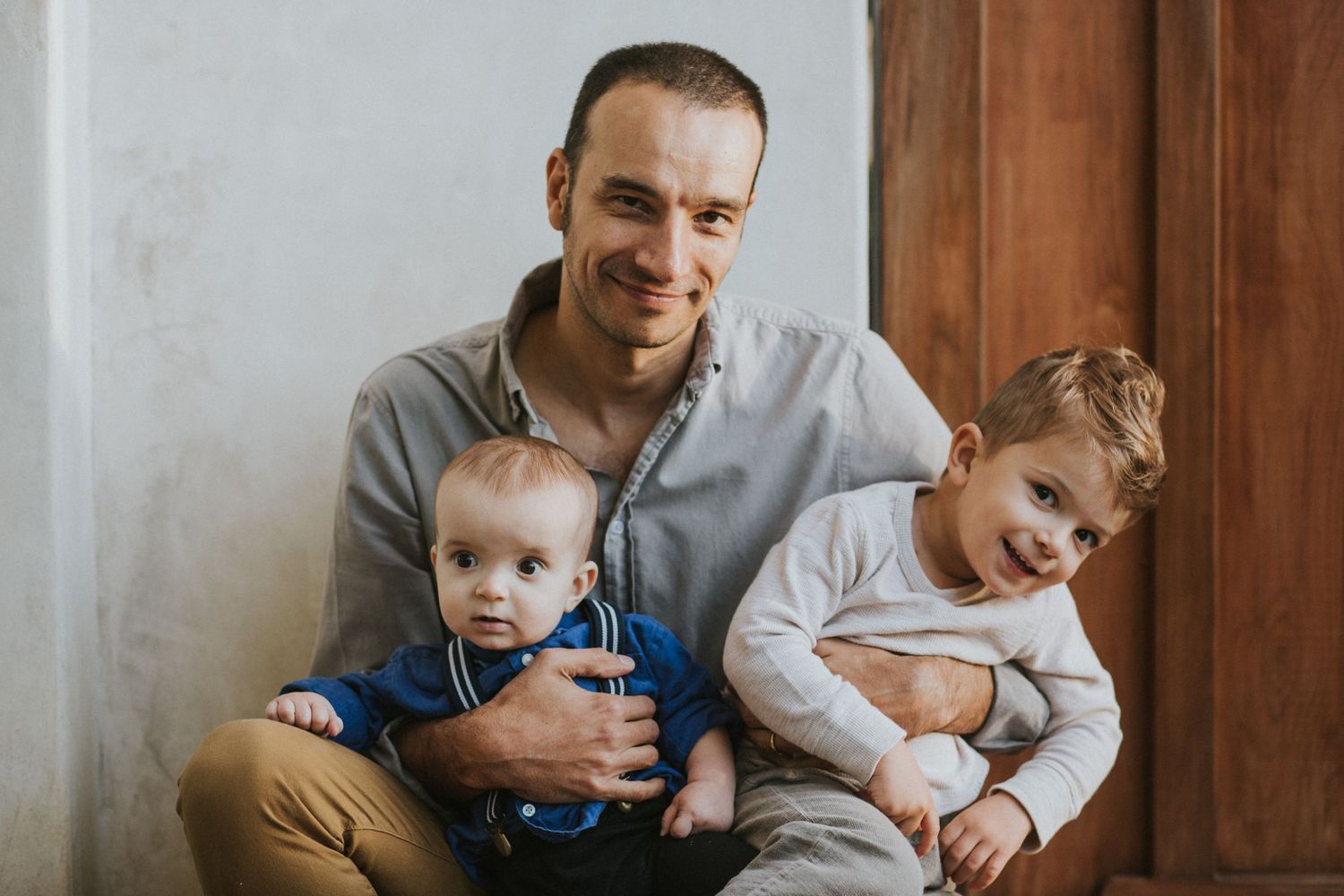 Family moment captured indoors with natural lighting and wooden accents.