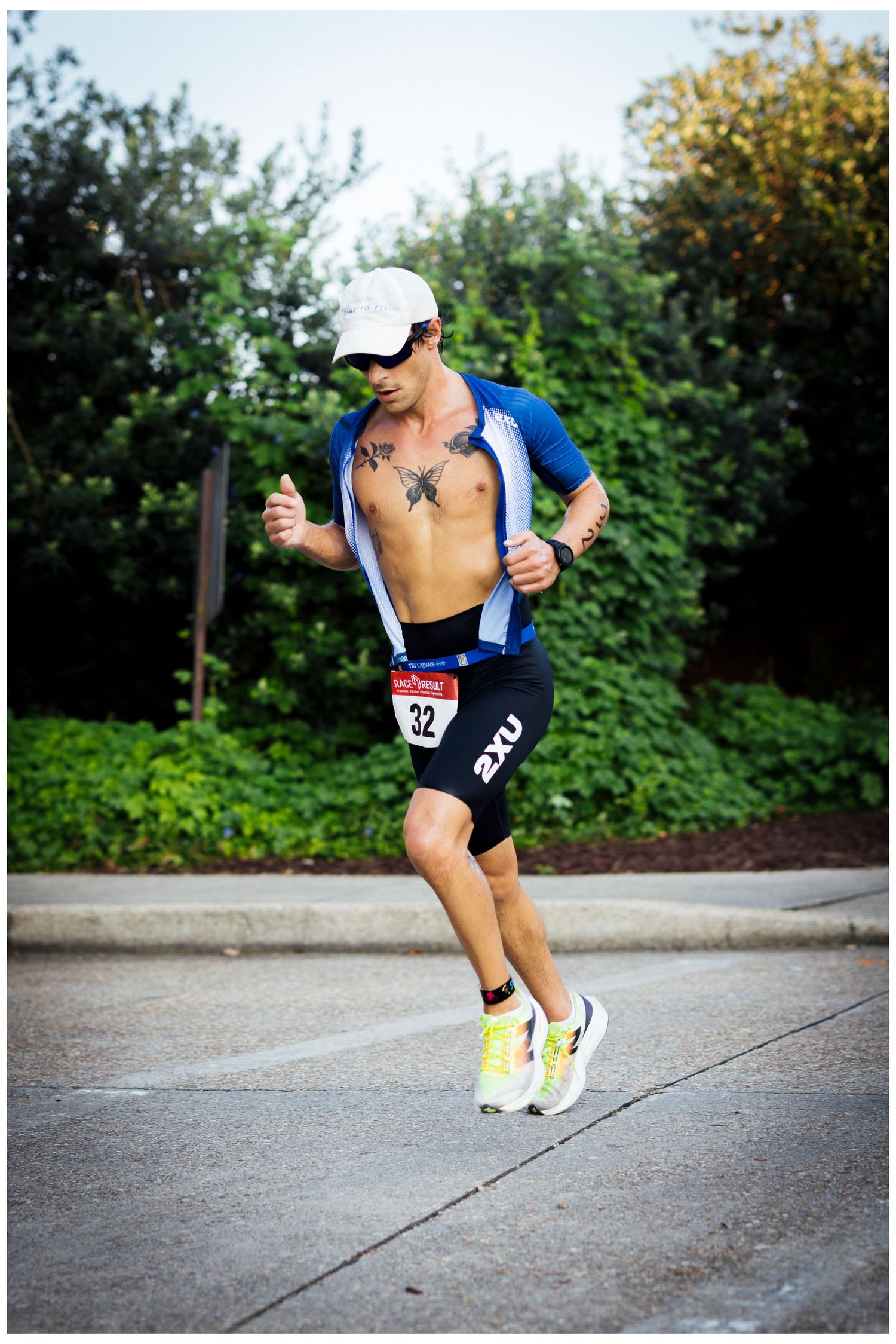 Athletic competitor running during triathlon race wearing race number bib.