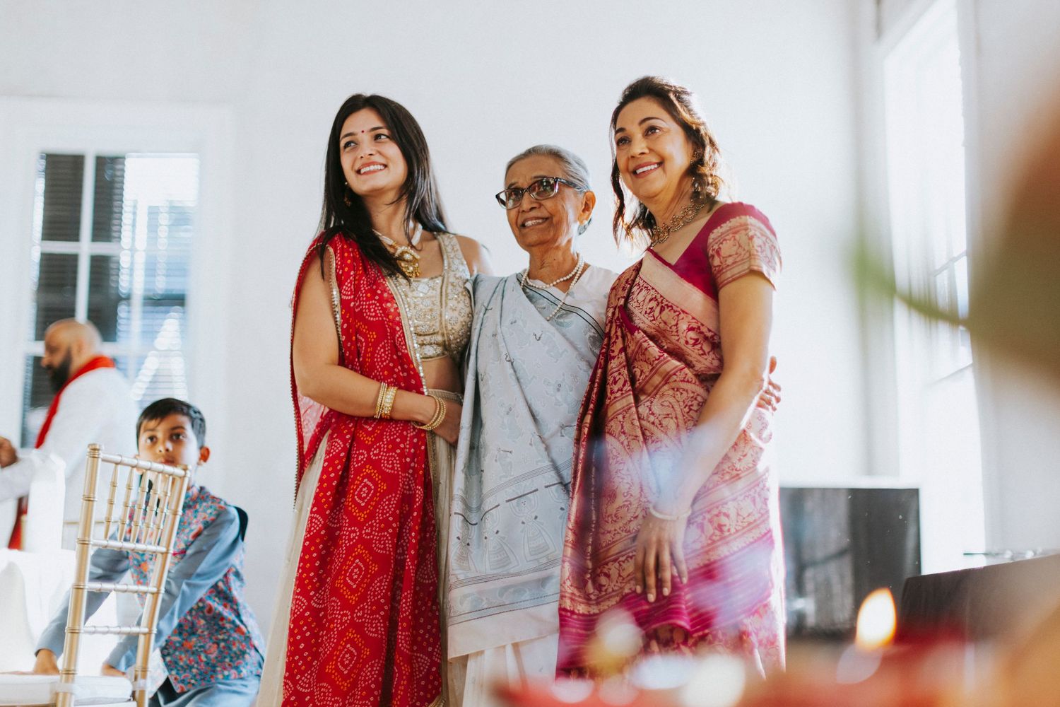 A happy family in colorful outfits shares joyful moments together in a bright indoor space.