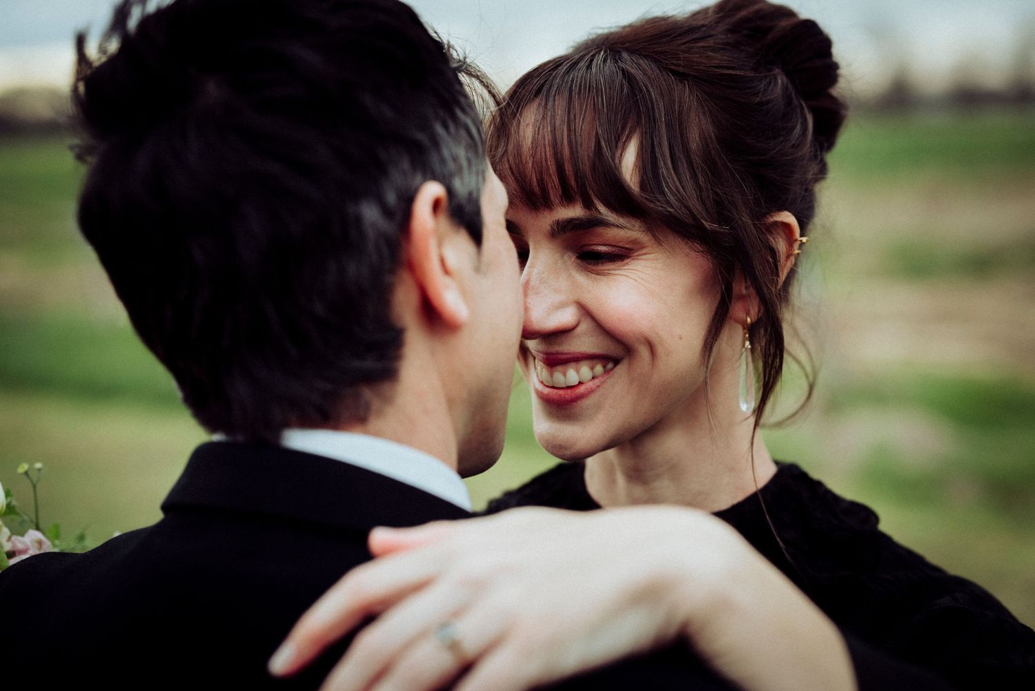 An intimate outdoor portrait showing two people sharing a joyful romantic moment.