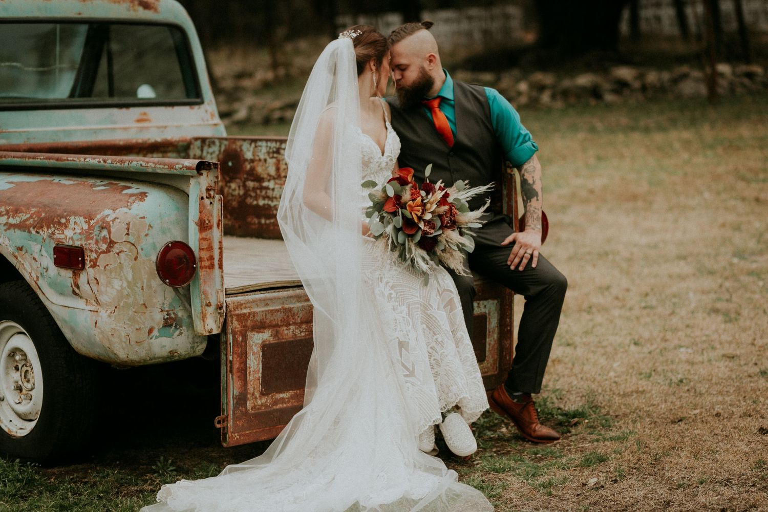 Vintage rustic truck wedding portrait with fall-themed florals.