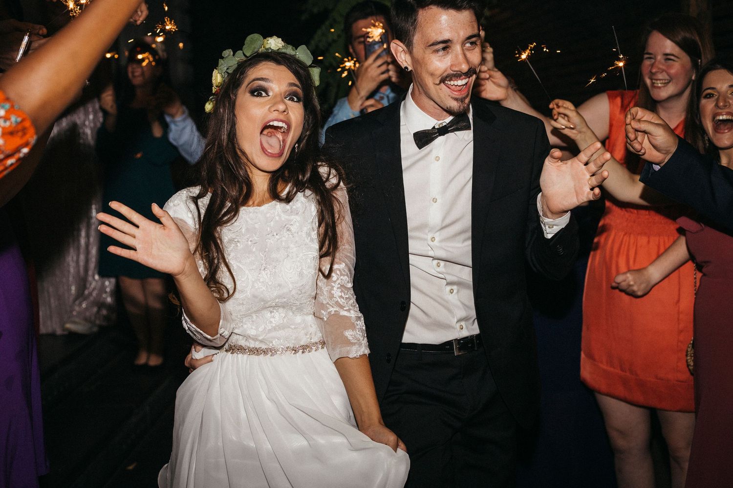People dancing and celebrating at a wedding reception with lively party atmosphere.