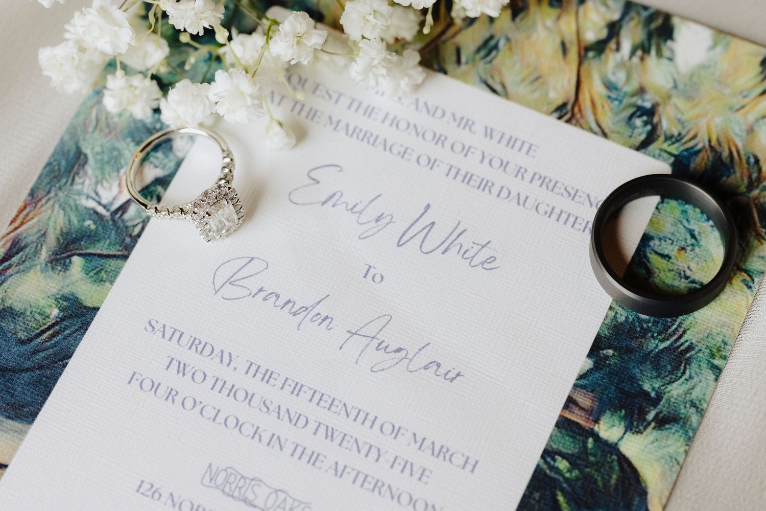 Elegant wedding invitation suite with calligraphy text and floral designs on white paper against a patterned background.
