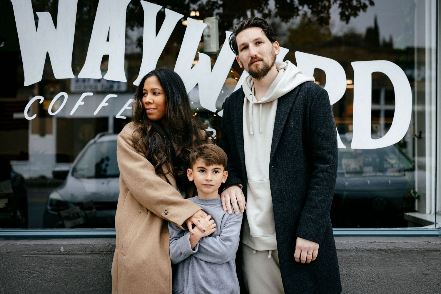 A family stands together outside a coffee shop storefront with Wayward signage.