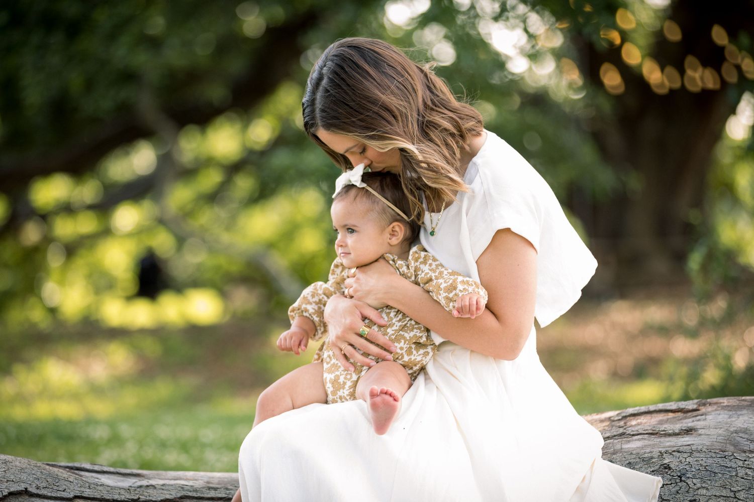 Tender family moment captured outdoors in natural lighting.