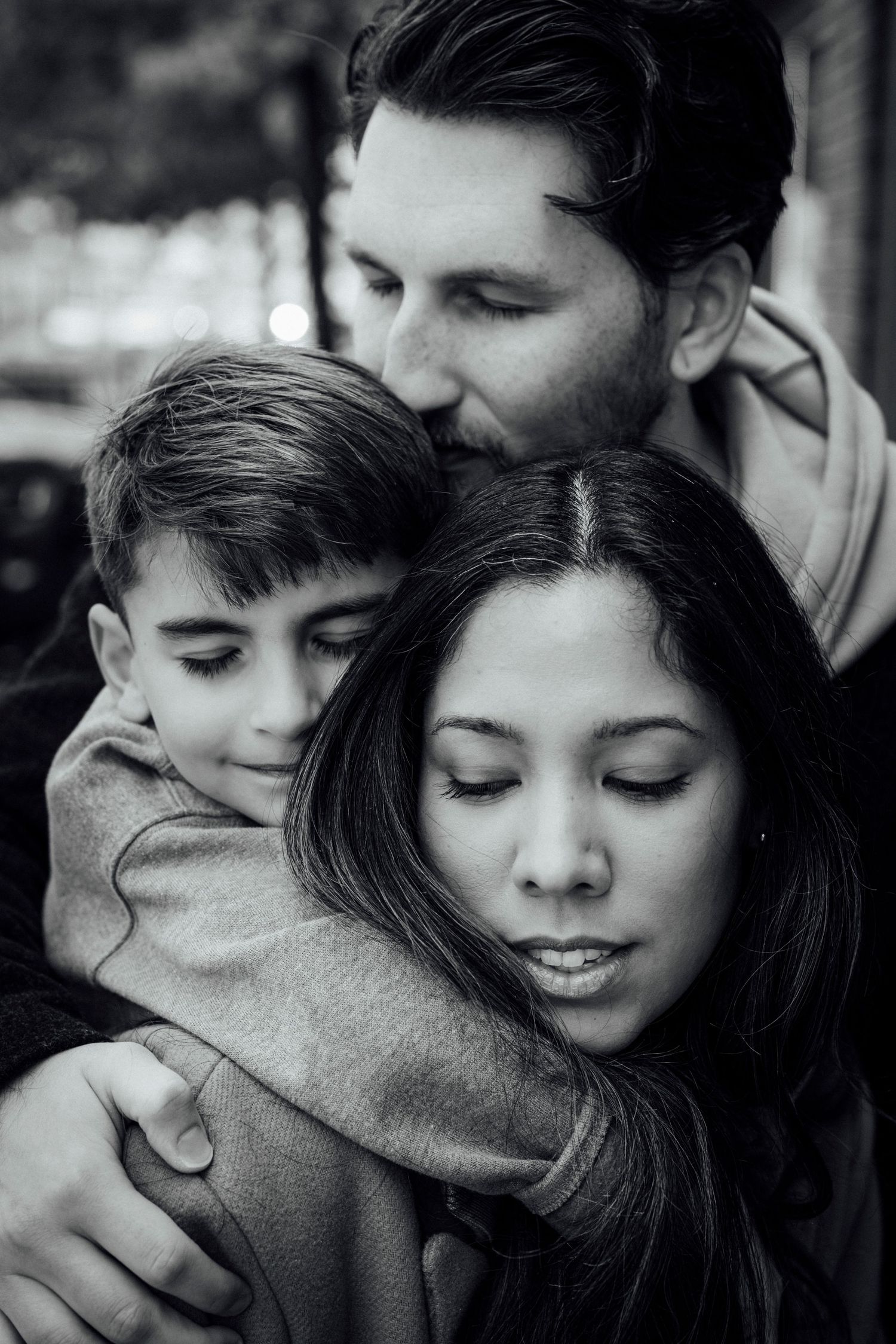 An intimate black and white family portrait showing a tender embrace.