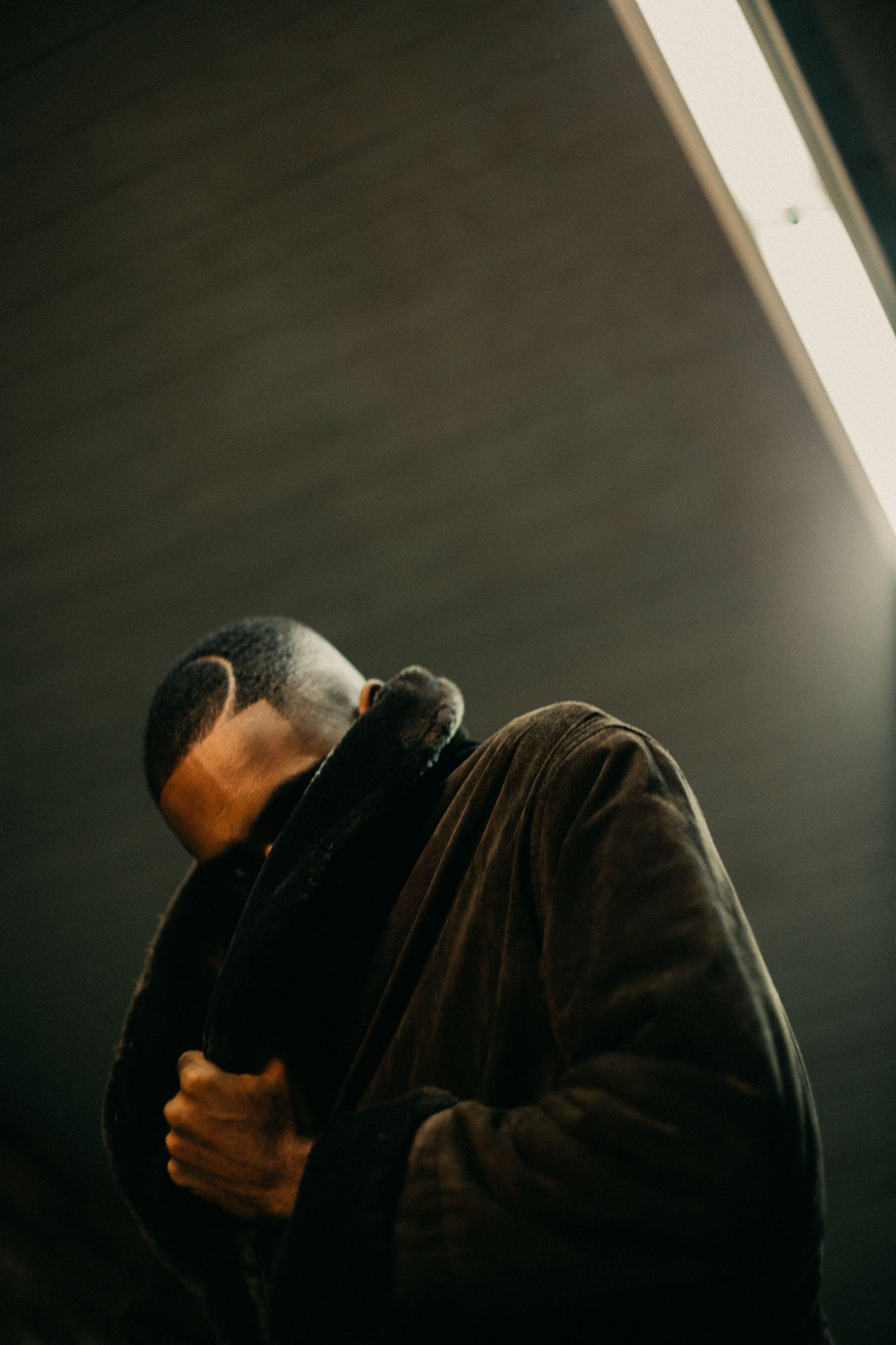 Artistic profile portrait in dark tones with moody lighting.
