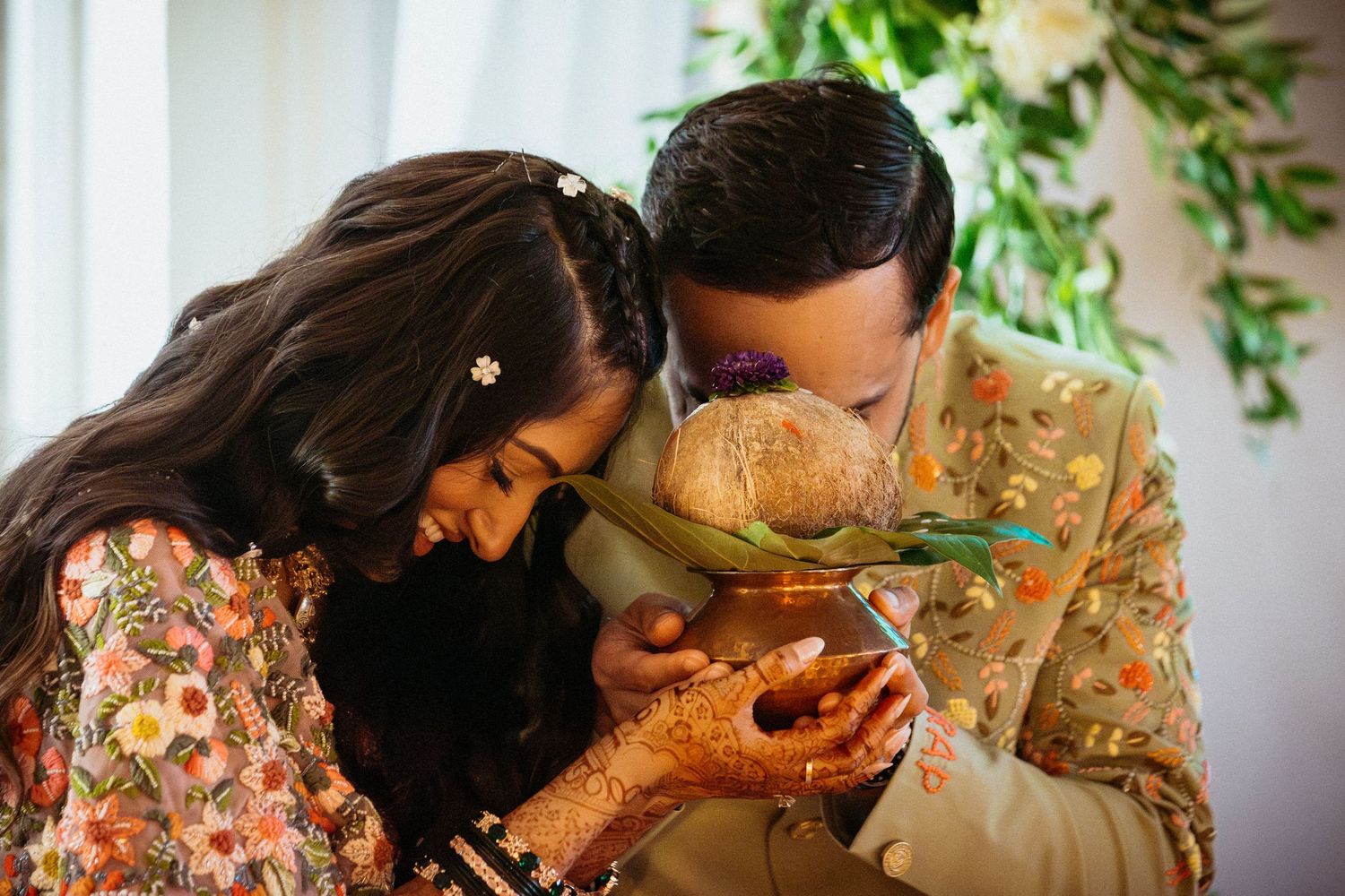 Couple sharing a moment with decorative details and greenery.