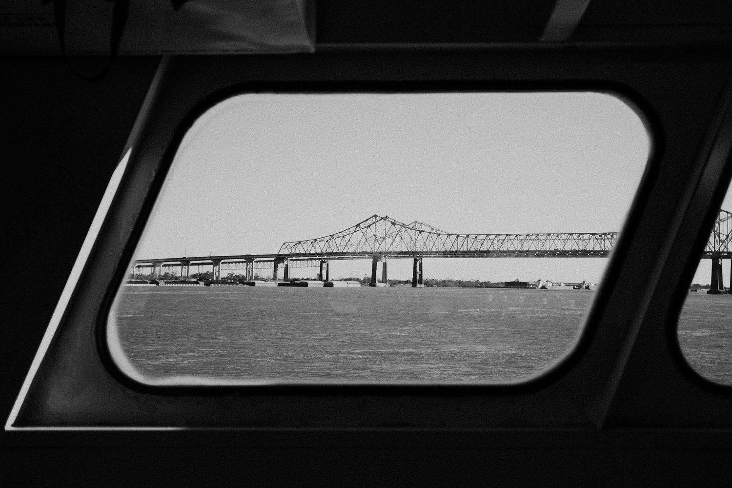 Bridge seen through ship window in black and white photography.