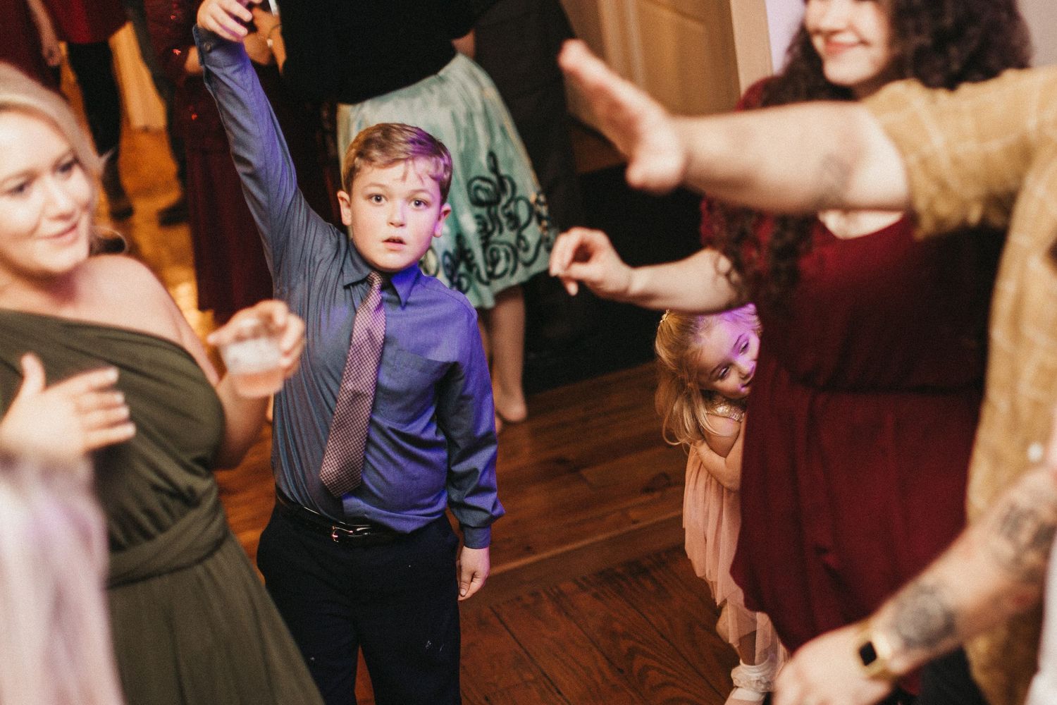 Energetic dance floor scene with wedding guests in formal attire.