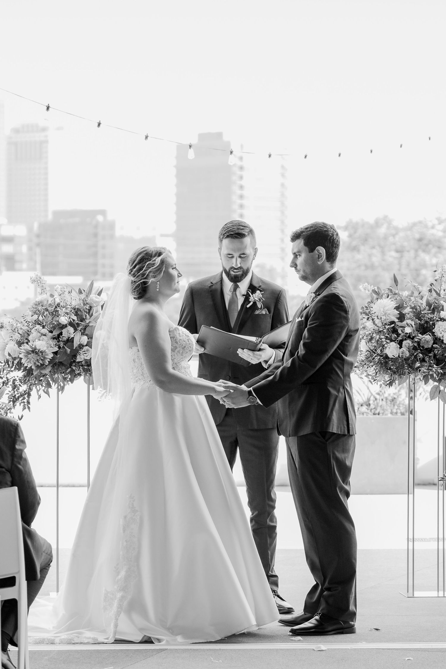 Black and white wedding ceremony photos showing couple exchanging vows with officiant in elegant outdoor setting.