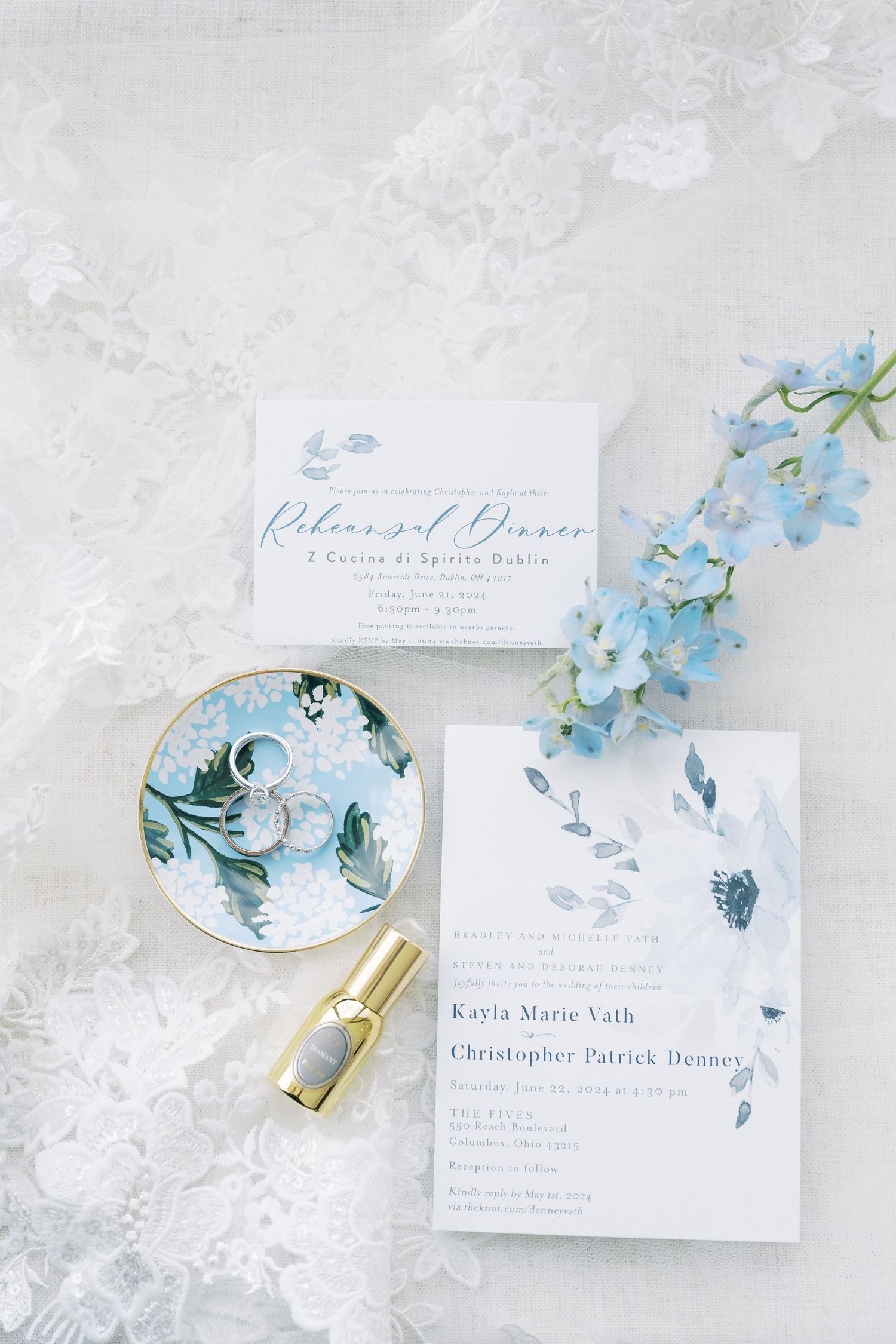 Elegant wedding invitation suite with blue floral design, gold lipstick and delicate lace background.