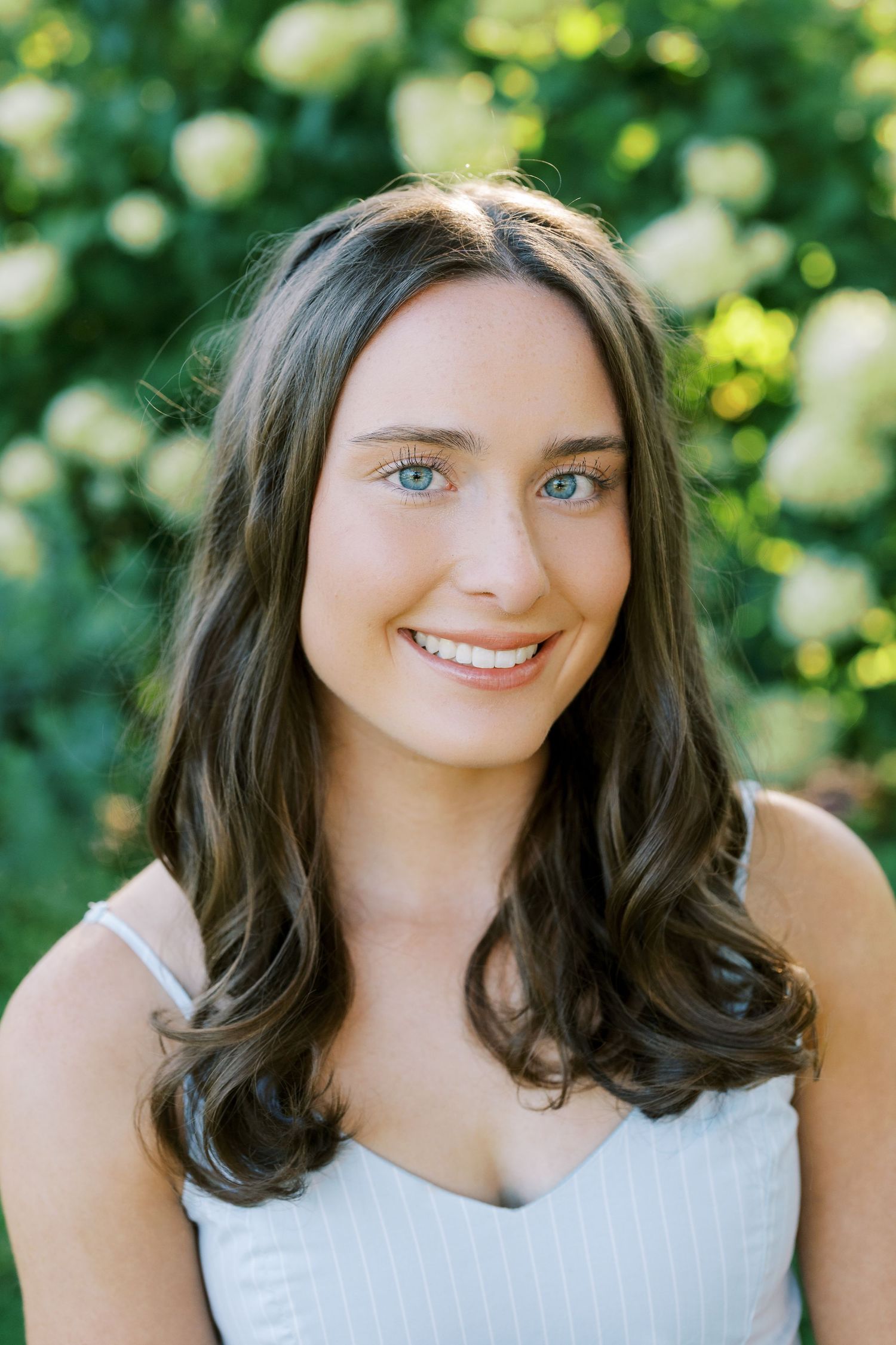A portrait series showing a person with dark brown hair and white top against a soft green natural background.