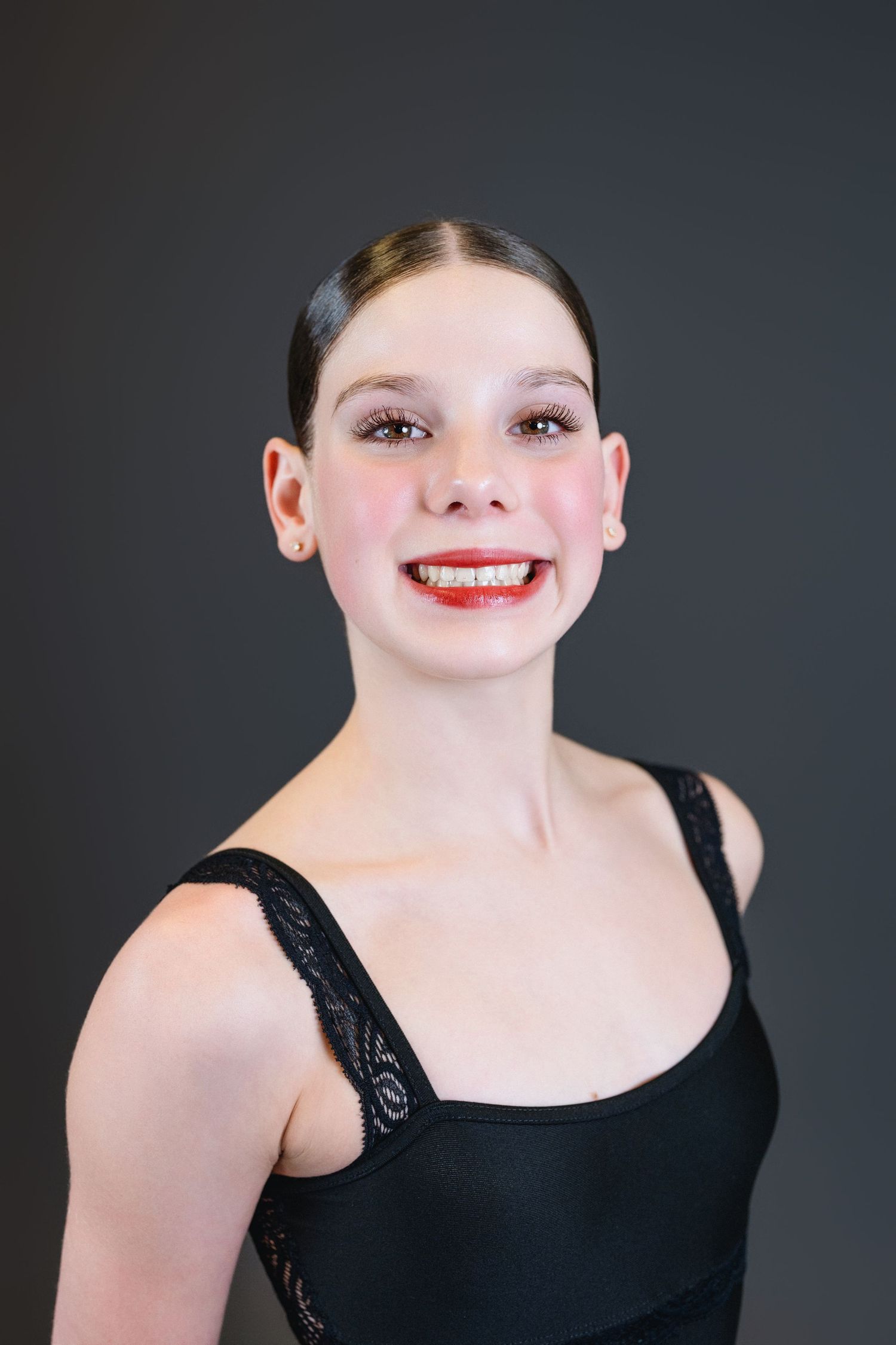 A sequence of headshots showing a person wearing a black top and red lipstick against a dark background.