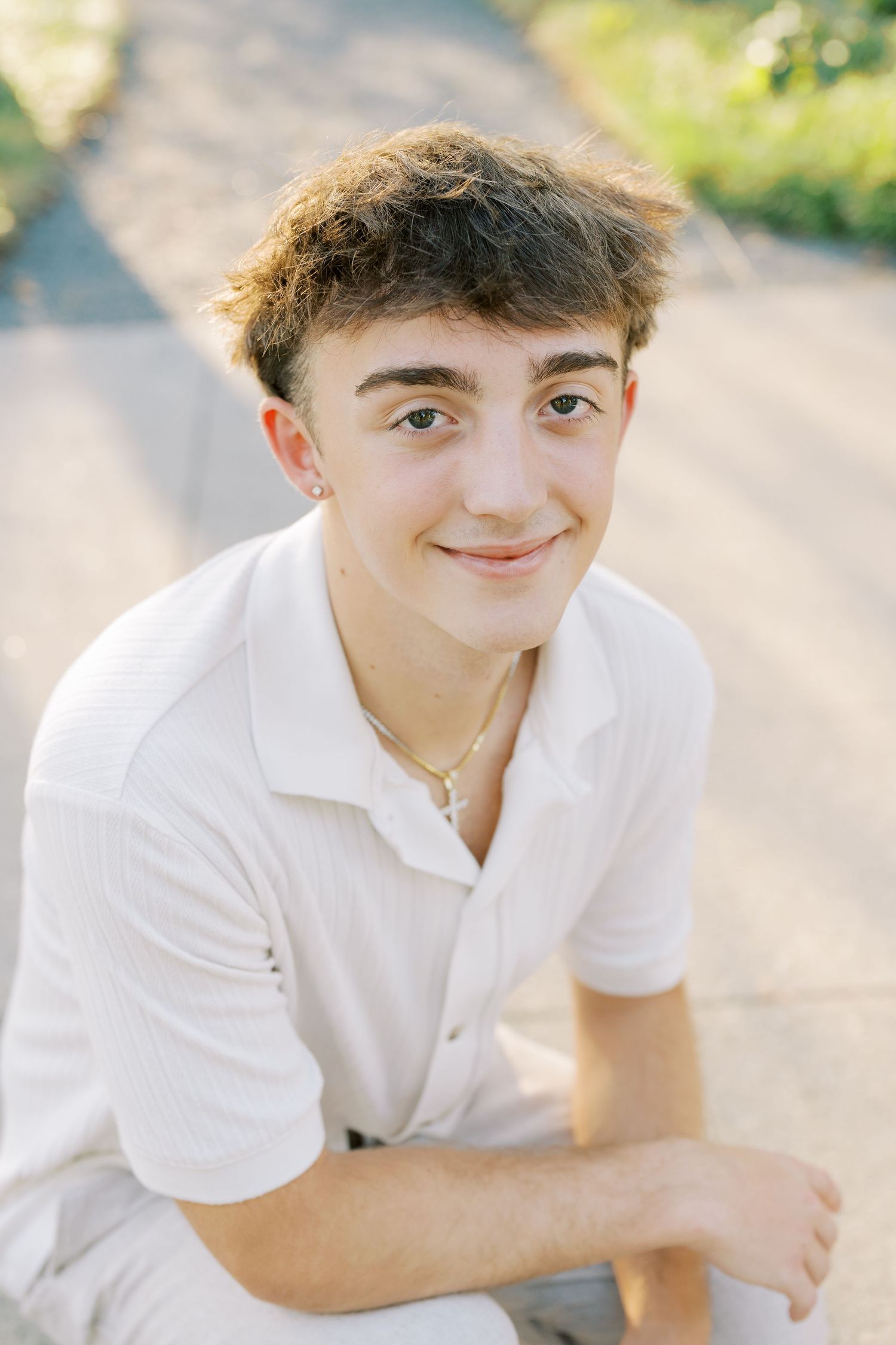Young person in white polo shirt poses outdoors with natural lighting in a series of casual portraits.