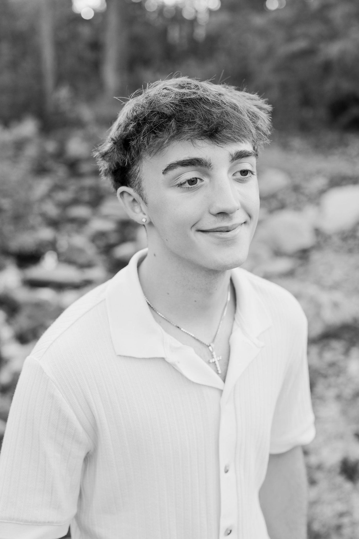 Black and white portrait series showing someone in a white shirt against a blurred natural background.