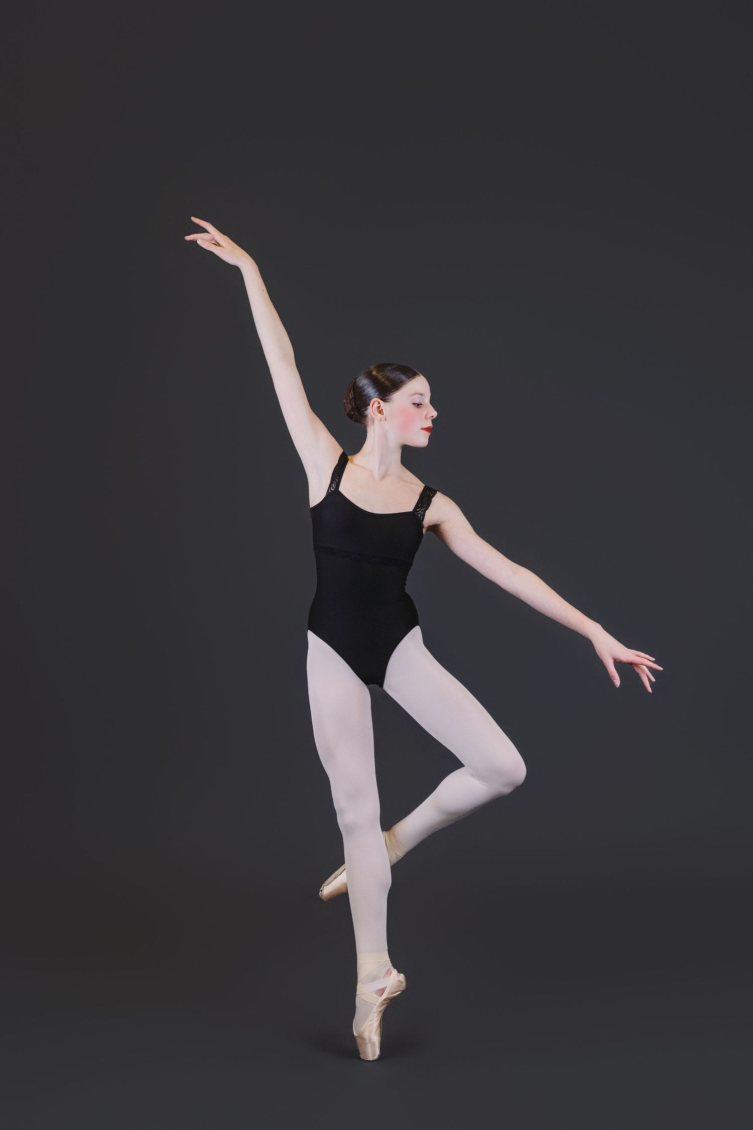 Ballet dancer in black leotard performs graceful arabesque poses against dark background in four-image sequence.
