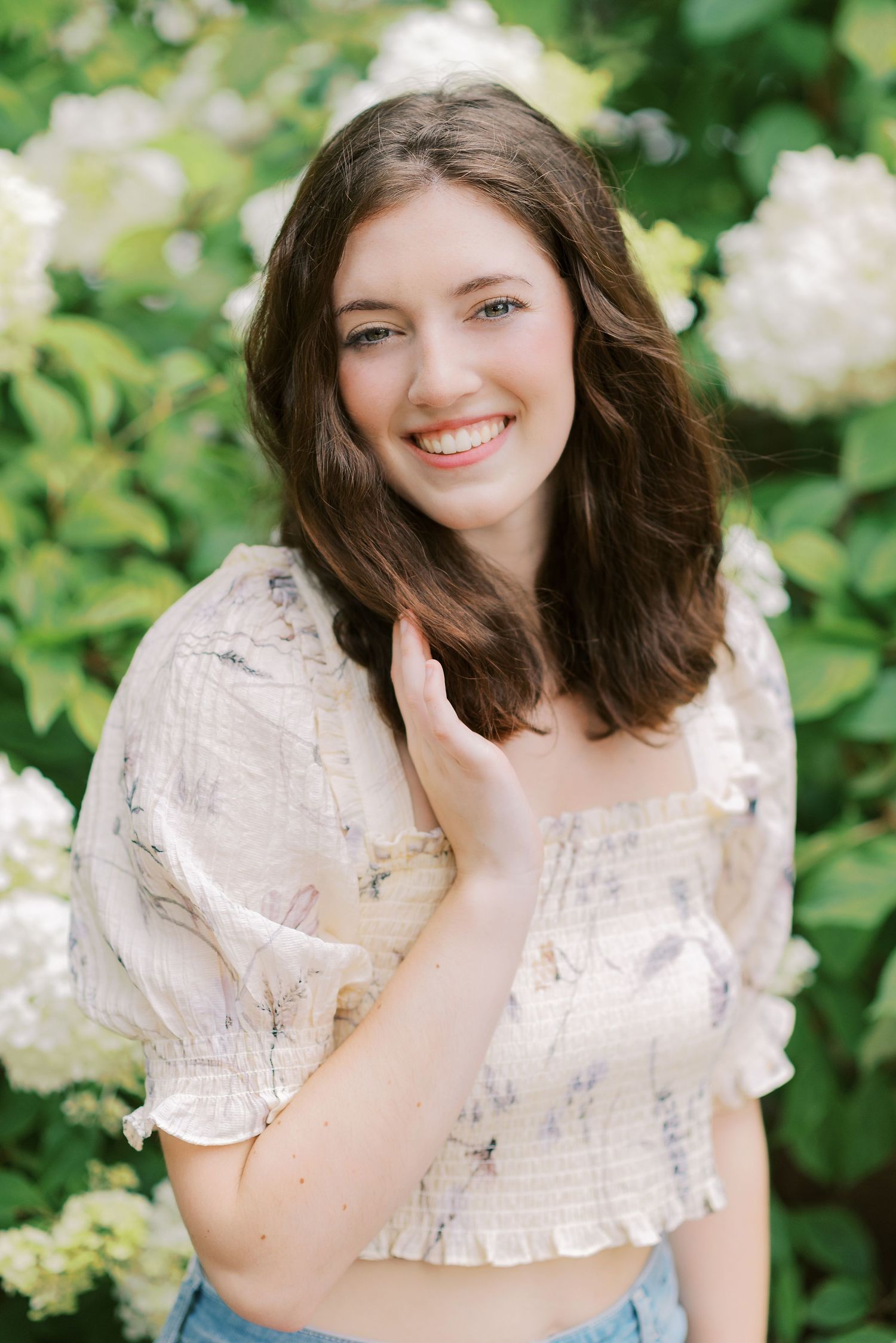 Portrait series in a garden with white lace dress and natural greenery backdrop.