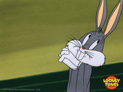 Bugs Bunny cartoon character smiling and rubbing hands together in classic Looney Tunes animation style.