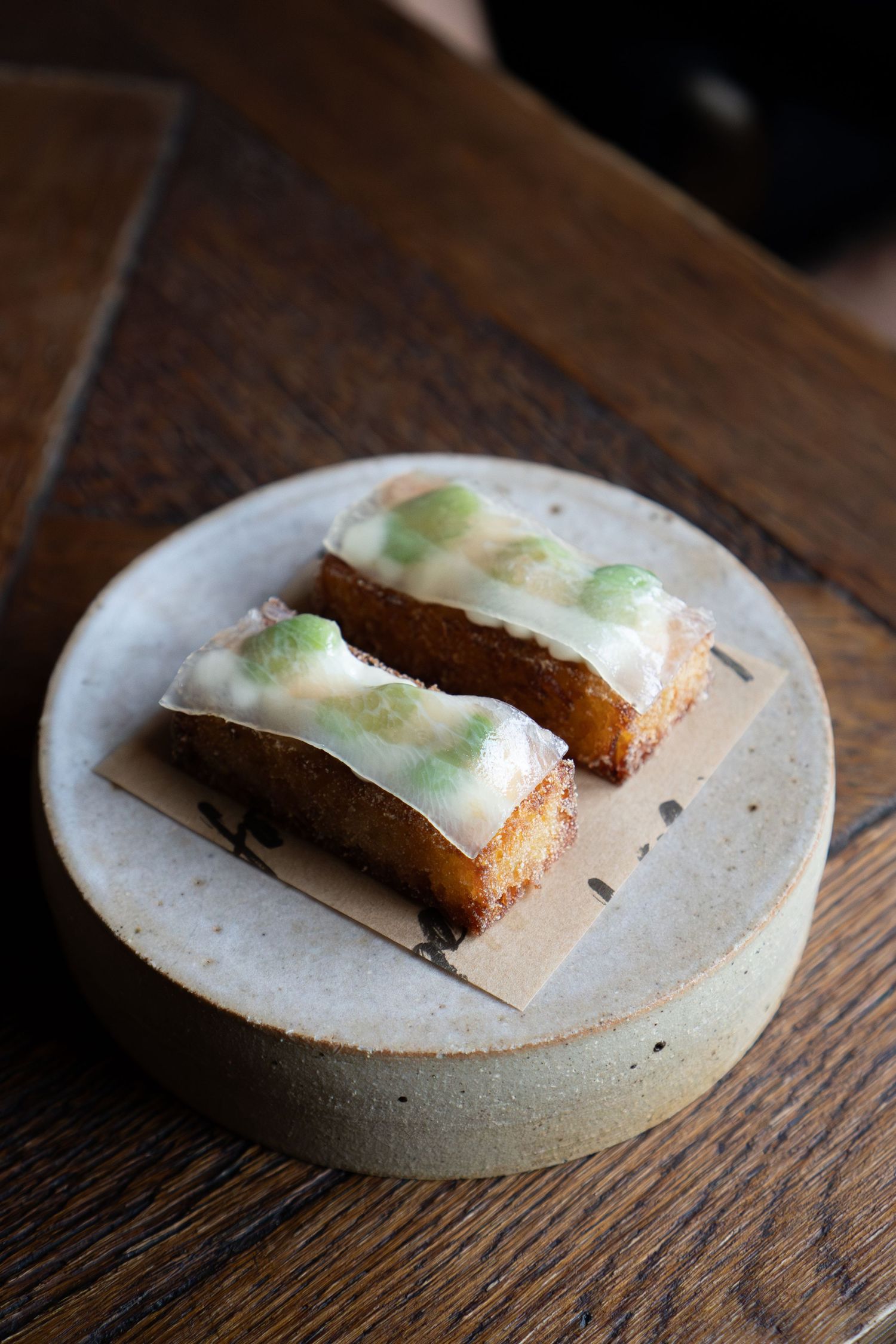 Two rectangular pieces of cake with white frosting and green garnish served on a round ceramic plate.