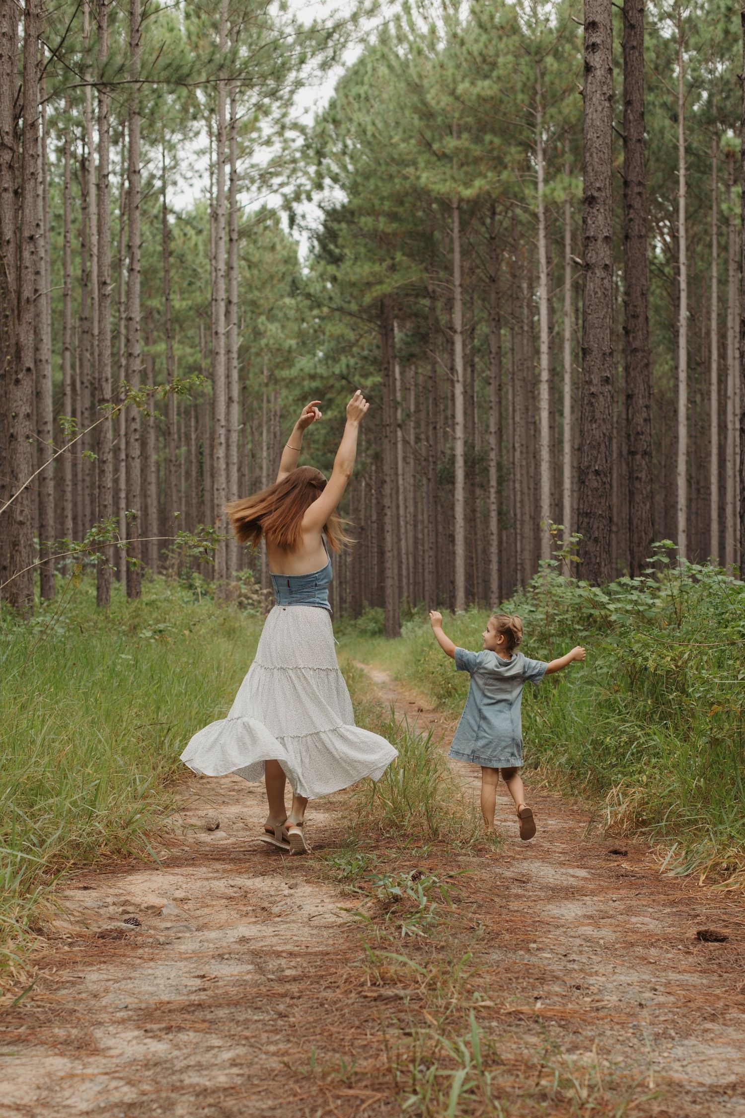 Two children playing together on a forest trail.