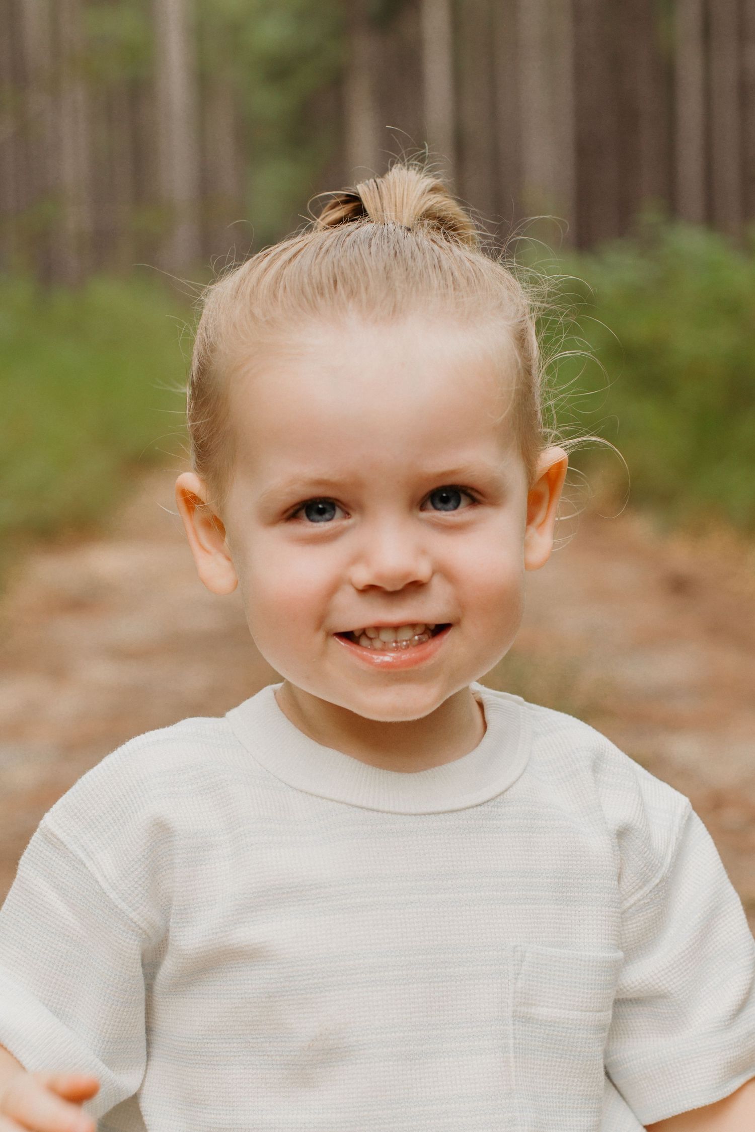 Toddler portrait on a forest trail during a family photography session.